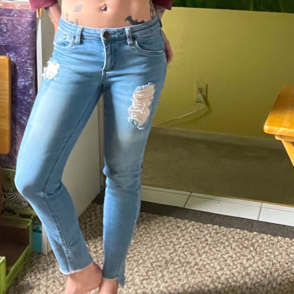 Light jeans with leg tear detail.